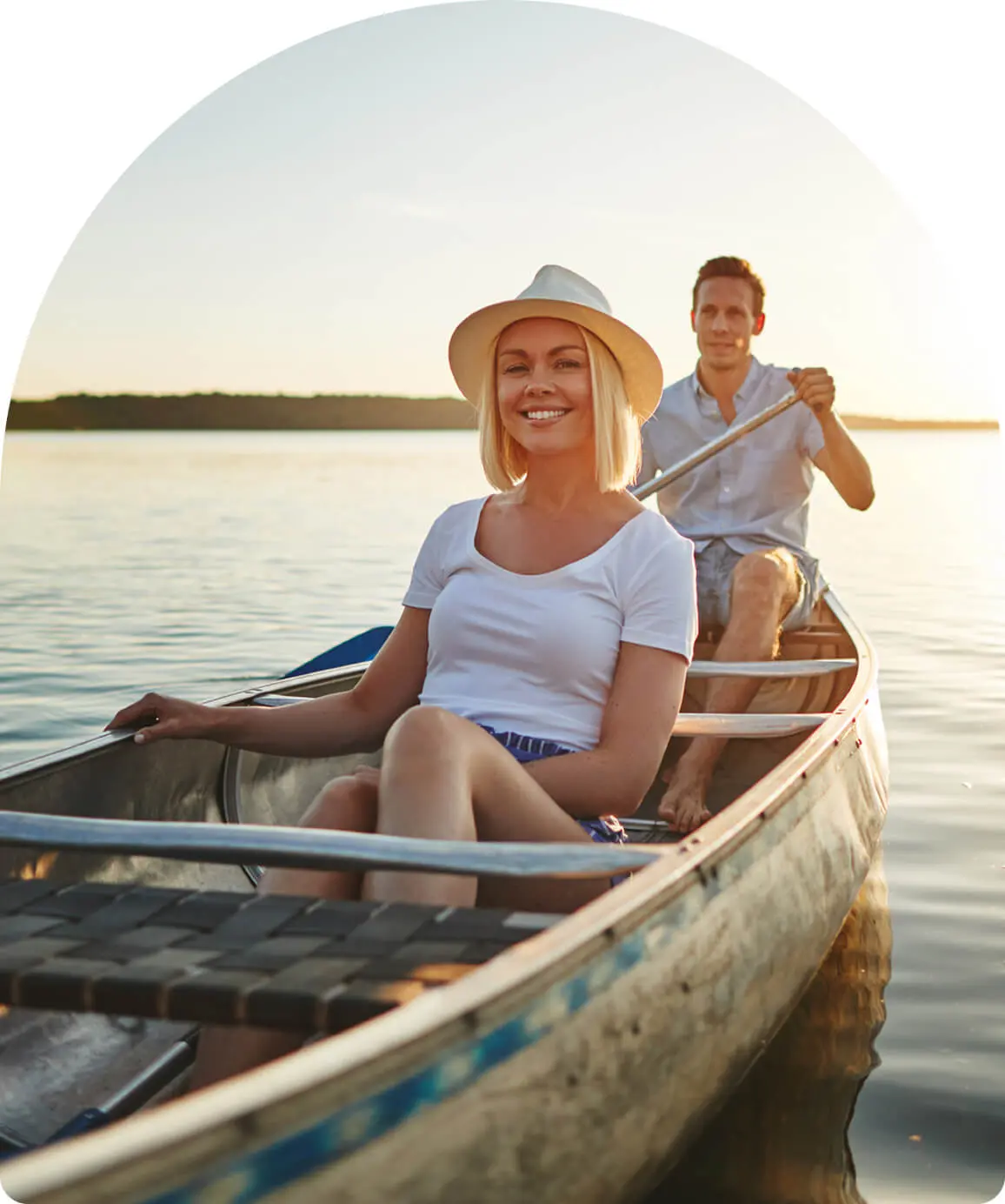 Couple canoeing on a serene lake.