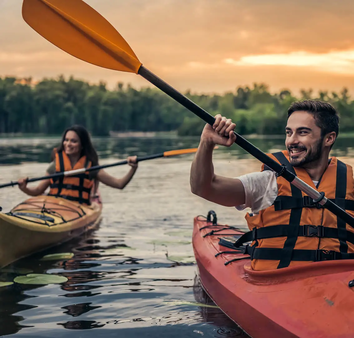 Two people kayaking on a calm lake.